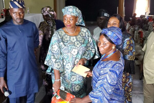 Mrs. Andrea Jonathan Gbwefi presenting food items and Cash to one of the beneficiaries.