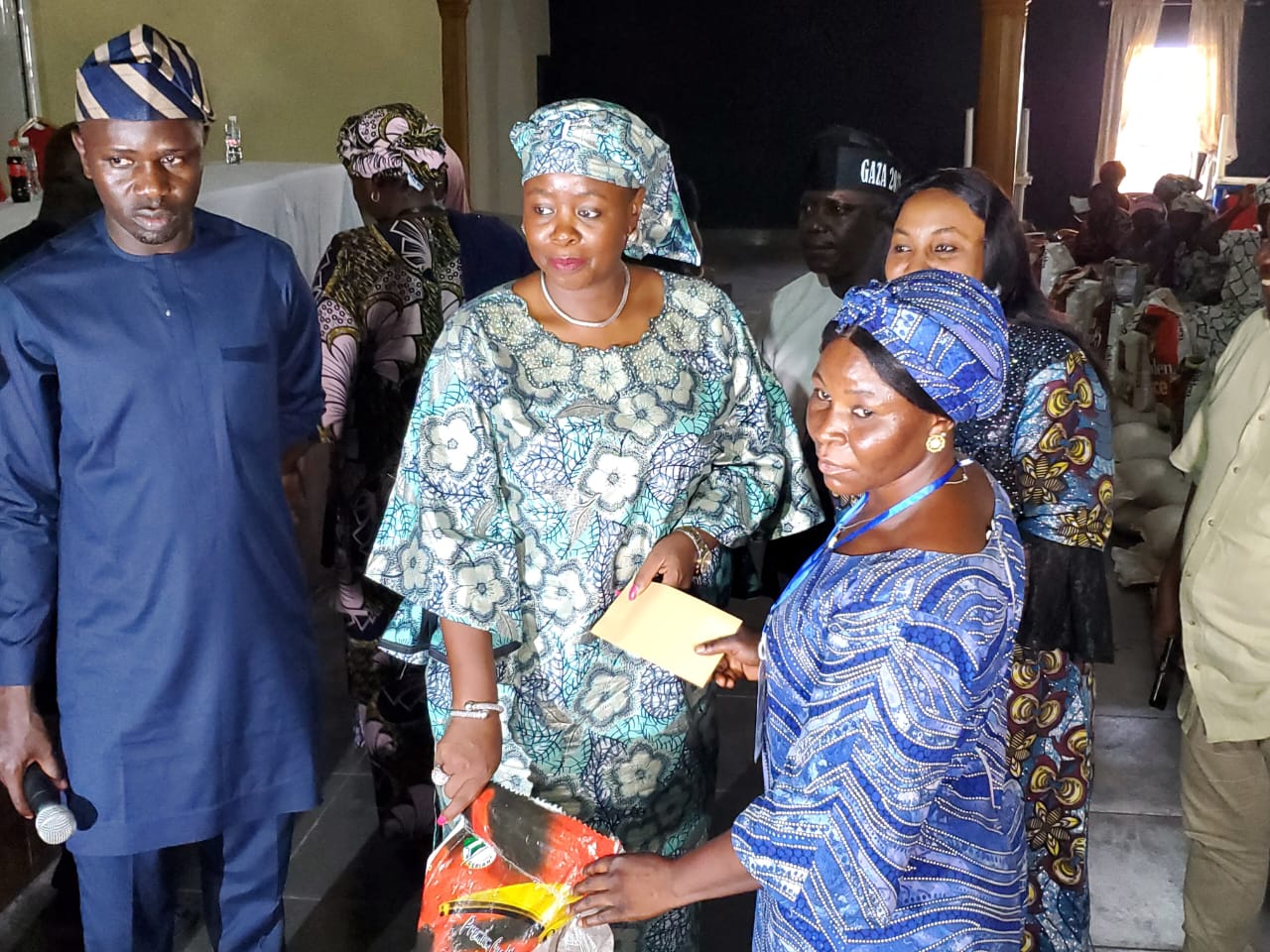 Mrs. Andrea Jonathan Gbwefi presenting food items and Cash to one of the beneficiaries.